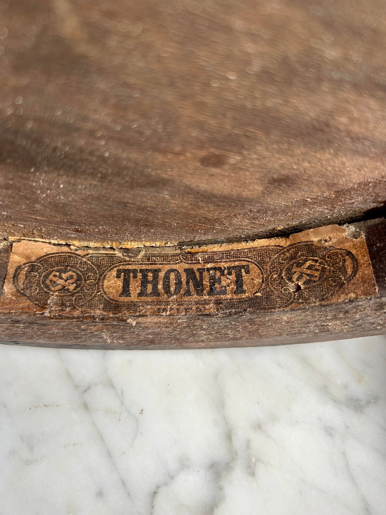 Wooden surface with 'Thonet' branding on a paper background